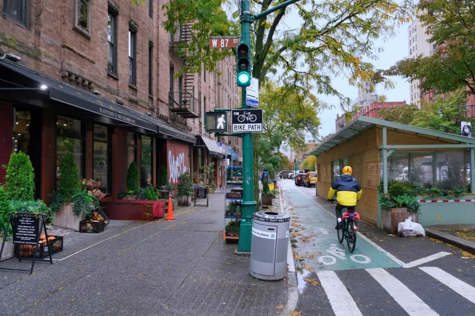 Green painted bike lane in New York City between sidewalk and outdoor dining kiosks
